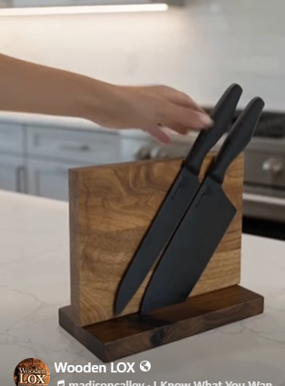 Handcrafted Wooden LOX magnetic knife holder made of walnut and oak wood with three black-handled kitchen knives attached.