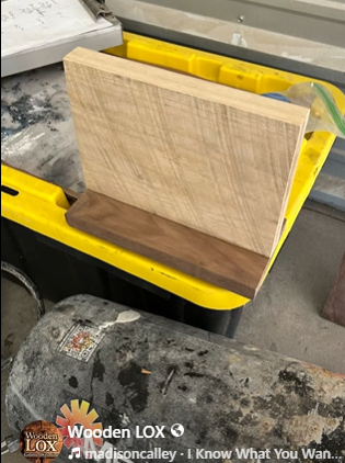 Handcrafted Wooden LOX magnetic knife holder made of walnut and oak wood with three black-handled kitchen knives attached.