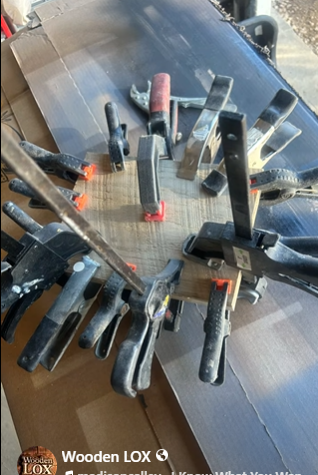 Handcrafted Wooden LOX magnetic knife holder made of walnut and oak wood with three black-handled kitchen knives attached.