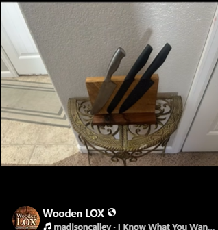 Handcrafted Wooden LOX magnetic knife holder made of walnut and oak wood with three black-handled kitchen knives attached.