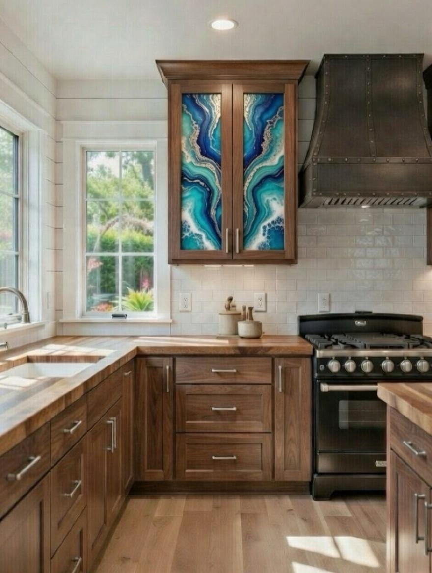 This image features a rustic-style kitchen highlighted by custom epoxy resin art panels integrated into the upper cabinet doors. Hand-poured blue and teal epoxy geode cabinet doors in a walnut kitchen.